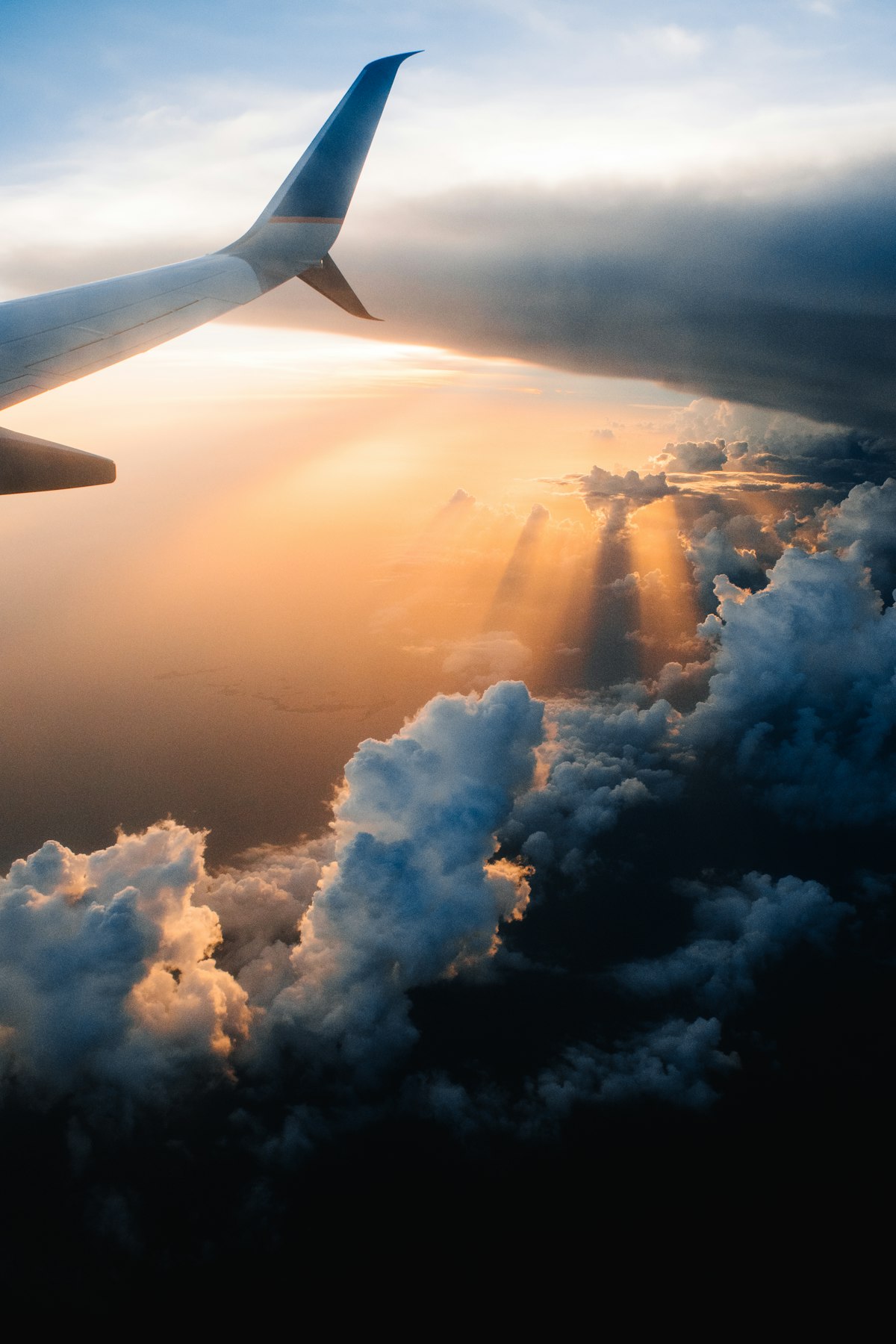 Expérience carte Amex Platinum en tant que voyageur belge : vue depuis un avion sur les nuages et le coucher de soleil